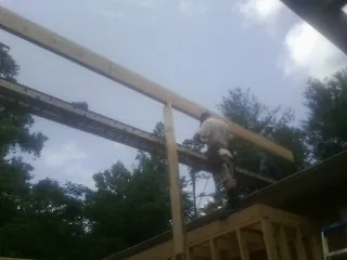 Carpenter setting a ridge beam over a new addition frame — Ice Dam Removal by Roofing Brothers in Lake Lynn