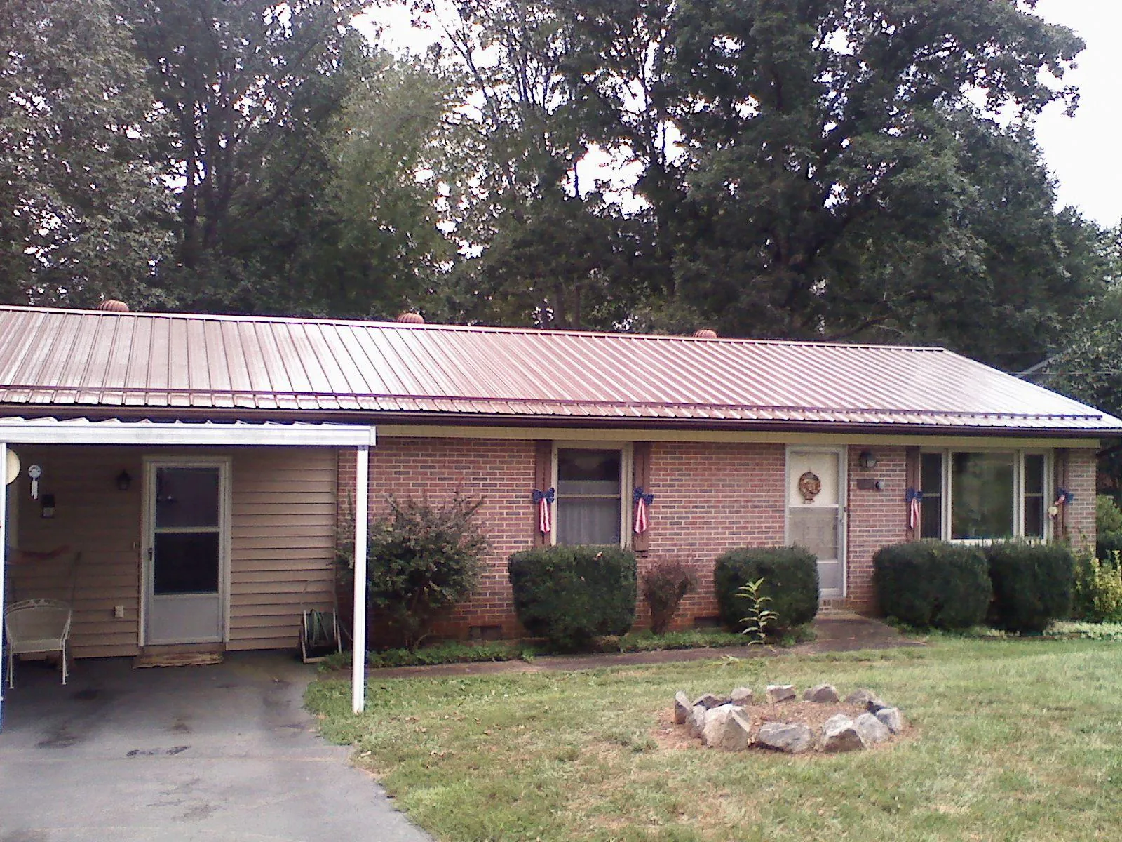 Bronze metal roof and carport on a brick ranch home — Roof Repair work by our crew in Lake Lynn